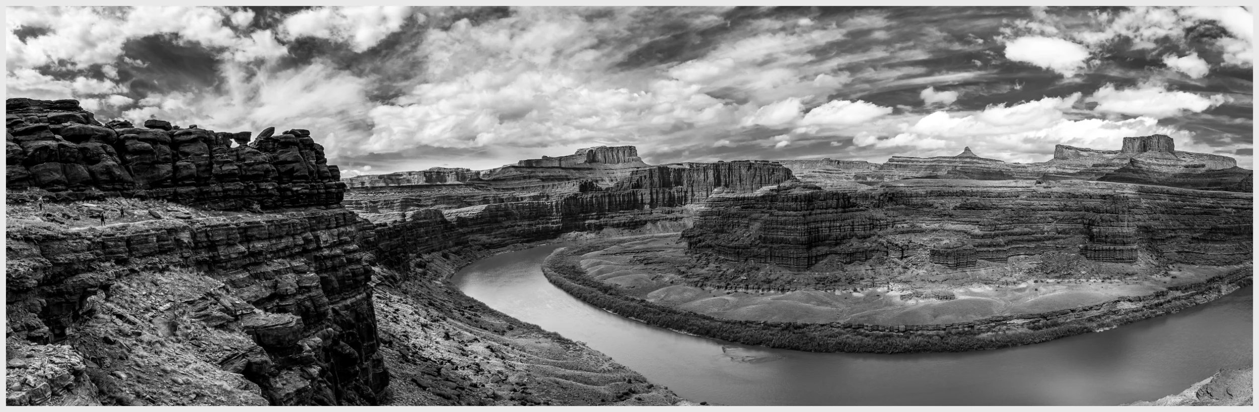 During the annual Jeep Safari in Moab, Utah, I captured this photograph at the end of the Chicken Corners trail, showcasing a breathtaking panorama of the Colorado River winding through Moab's iconic cliffs and mesas. Joined by my parents, we savored this view while sharing a meal, immersing ourselves in the beauty of nature. The photograph highlights the dramatic interplay of light and shadow across the cliffs, enhancing the rugged beauty of the terrain. Drifting clouds above mirror the river's serpentine path, adding a dreamlike quality to the scene. This image is a tribute to Moab's enduring beauty, illustrating the profound impact of the Colorado River on this awe-inspiring landscape, and commemorating a cherished moment of connection with my parents amidst the grandeur of nature.